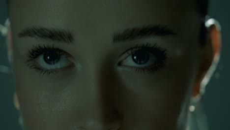 tight closeup capturing a woman’s intense eyes during training as the camera lowers to her lips, revealing sweat-drenched skin and breath control, framed in soft cinematic lighting and sharp detail