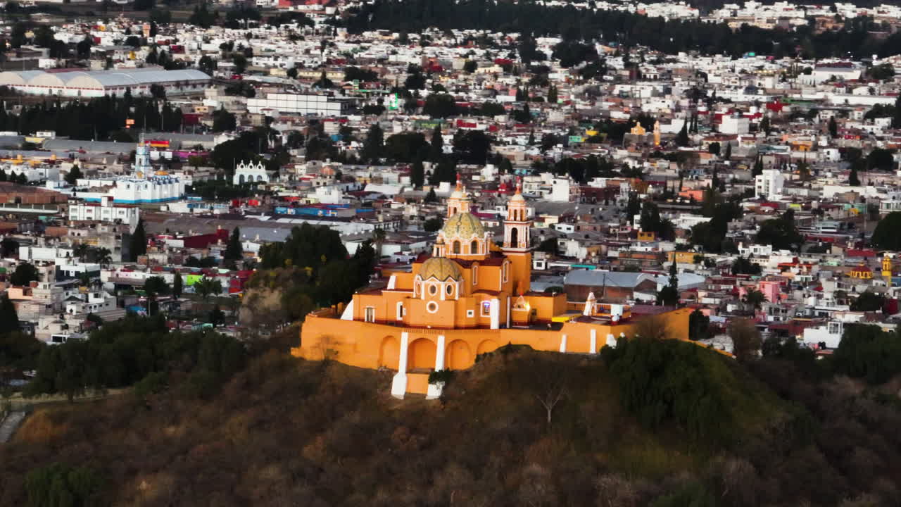 un drone de telezoom filmado dando vueltas alrededor de la iglesia en la pirámide de cholula, puesta de sol en méxico.