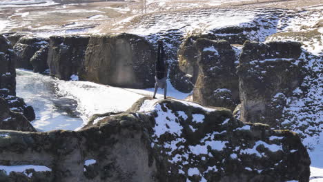 Joven-Viajero-En-Parada-De-Manos-En-Un-Camino-Empinado-En-El-Cañón-Fjadrargljufur-En-Invierno