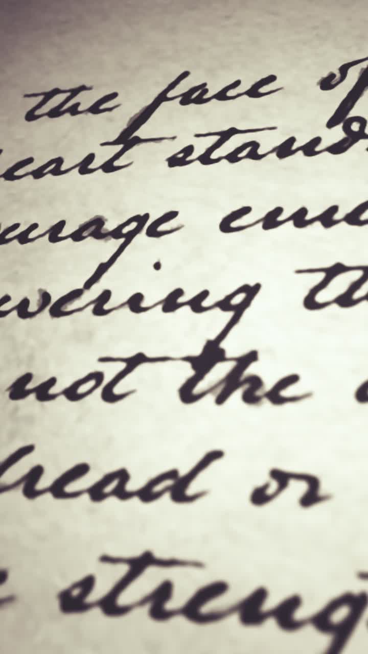 Close-up of Hand Writing Cursive Text with Pen on Paper