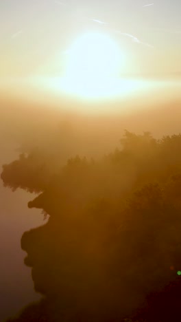 misty golden sunrise over a lake and forest