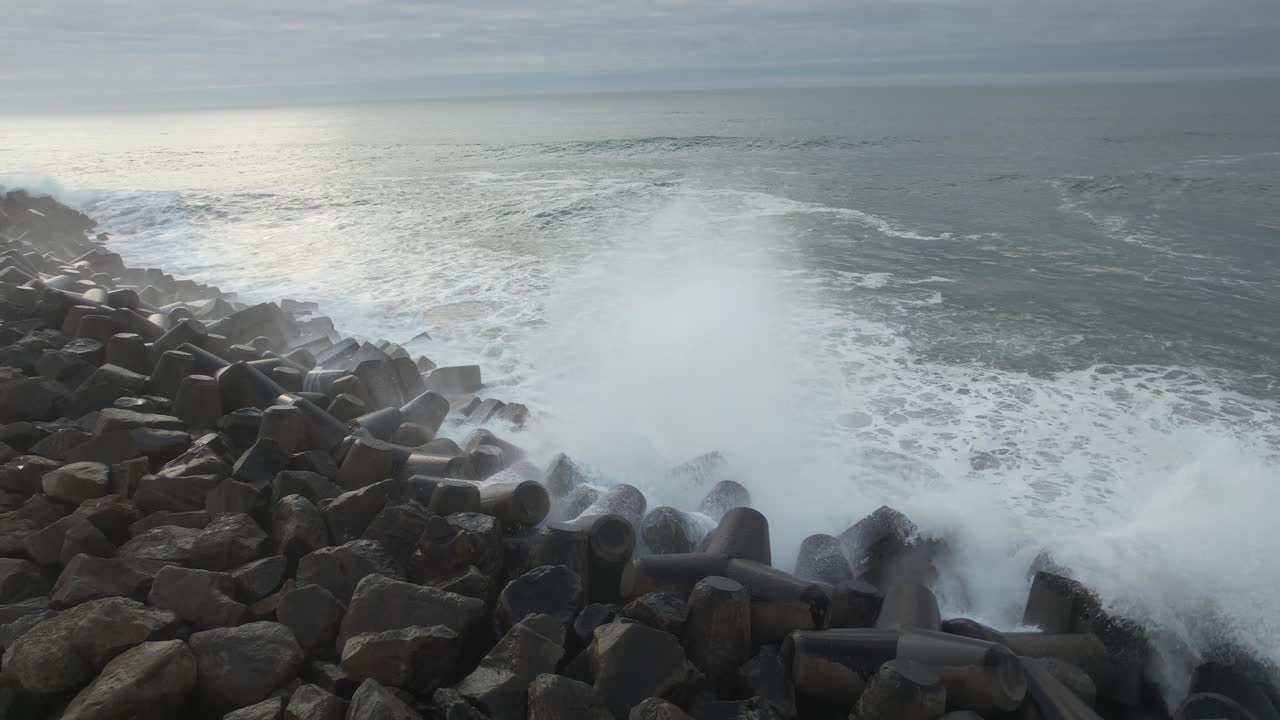 파도가 바위에 부딪치고, 거품이 이는 바닷물이 바위 표면 아래로 흐르고, 난류의 바다
