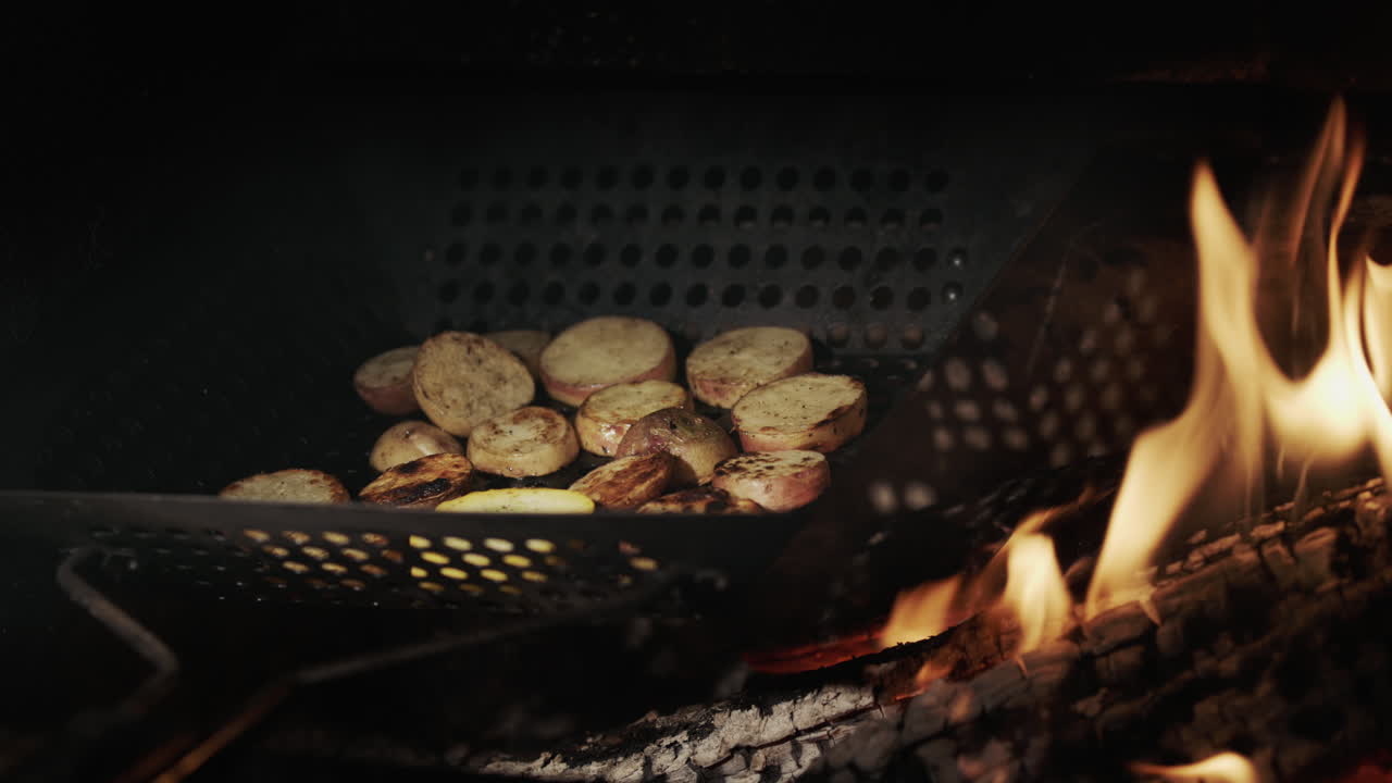 Potatoes are fried in the grill in a frying pan with holes