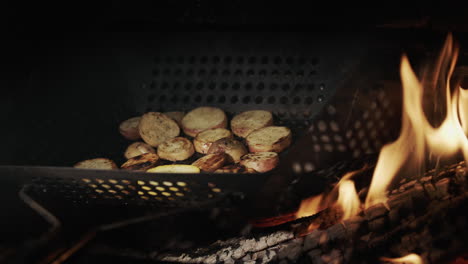 potatoes are fried in the grill in a frying pan with holes