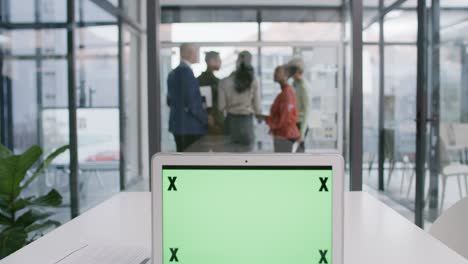 4k video footage of a group of businesspeople brainstorming on a glass wall in an office with a laptop displaying a green screen in the foreground