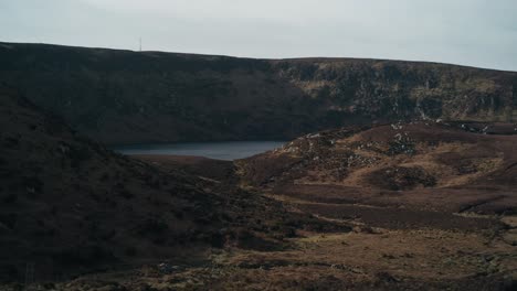 shot of lough bray upper in bray, county wicklow, ireland. the rugged landscape features rolling hills, rocky terrain, and a tranquil lake, capturing the beauty of ireland’s natural scenery.