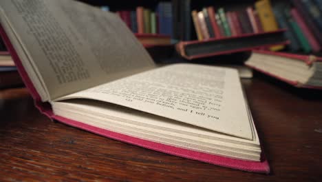 slow motion macro view of book with red cover is closed shut on desk in library