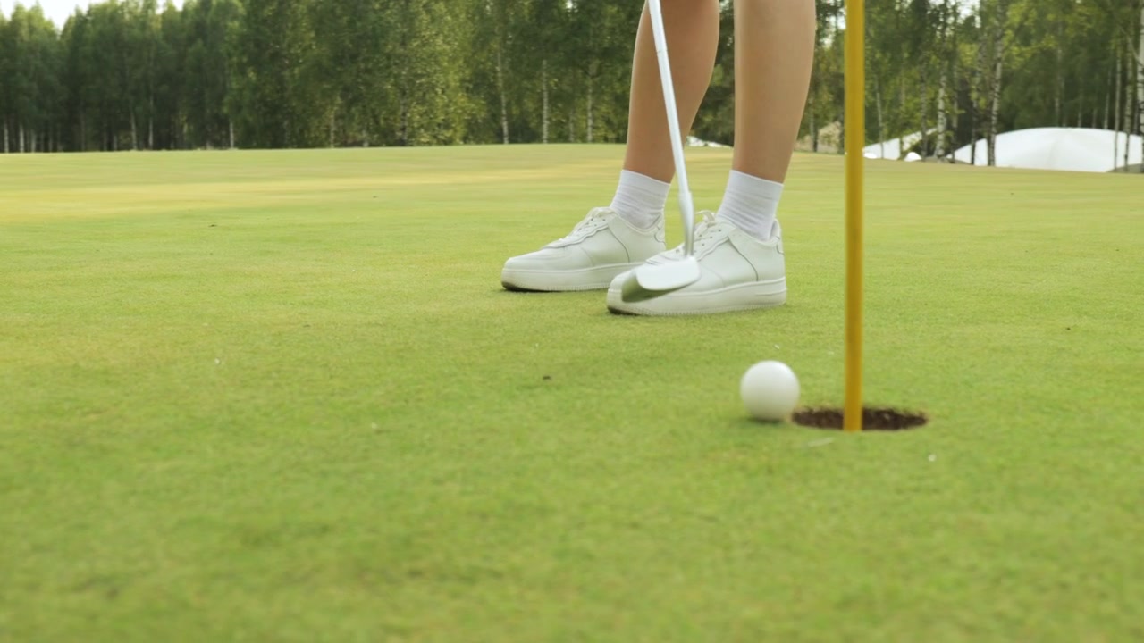 Primo Piano di una Persona che Mette una Pallina da Golf nella Buca