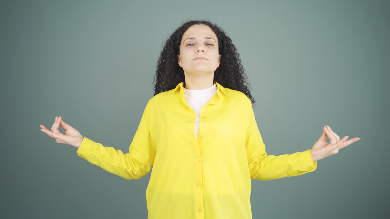mujer joven meditando mirando a la cámara.