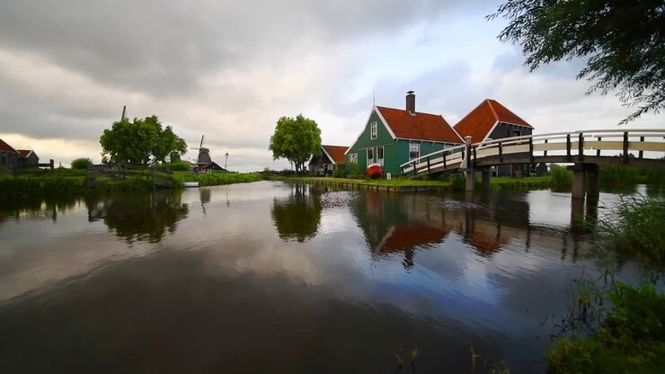Edificio della fabbrica di formaggio a Zaanse Schans riflesso sull'acqua calma del canale, a Zaandam, Paesi Bassi