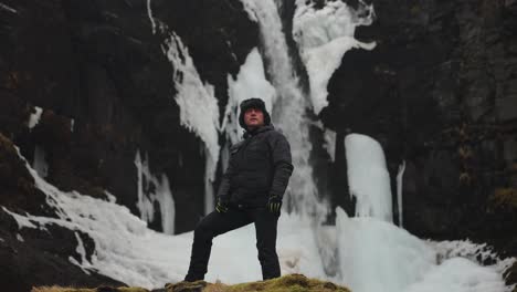 puesto turístico cerca de la cascada islandesa y el escuro acantilado volcánico escarpado