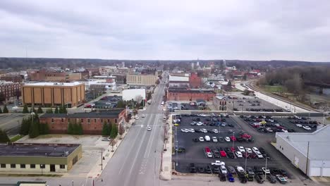 logansport, indiana aerial view flying downtown street past charming white church with spire in city parish