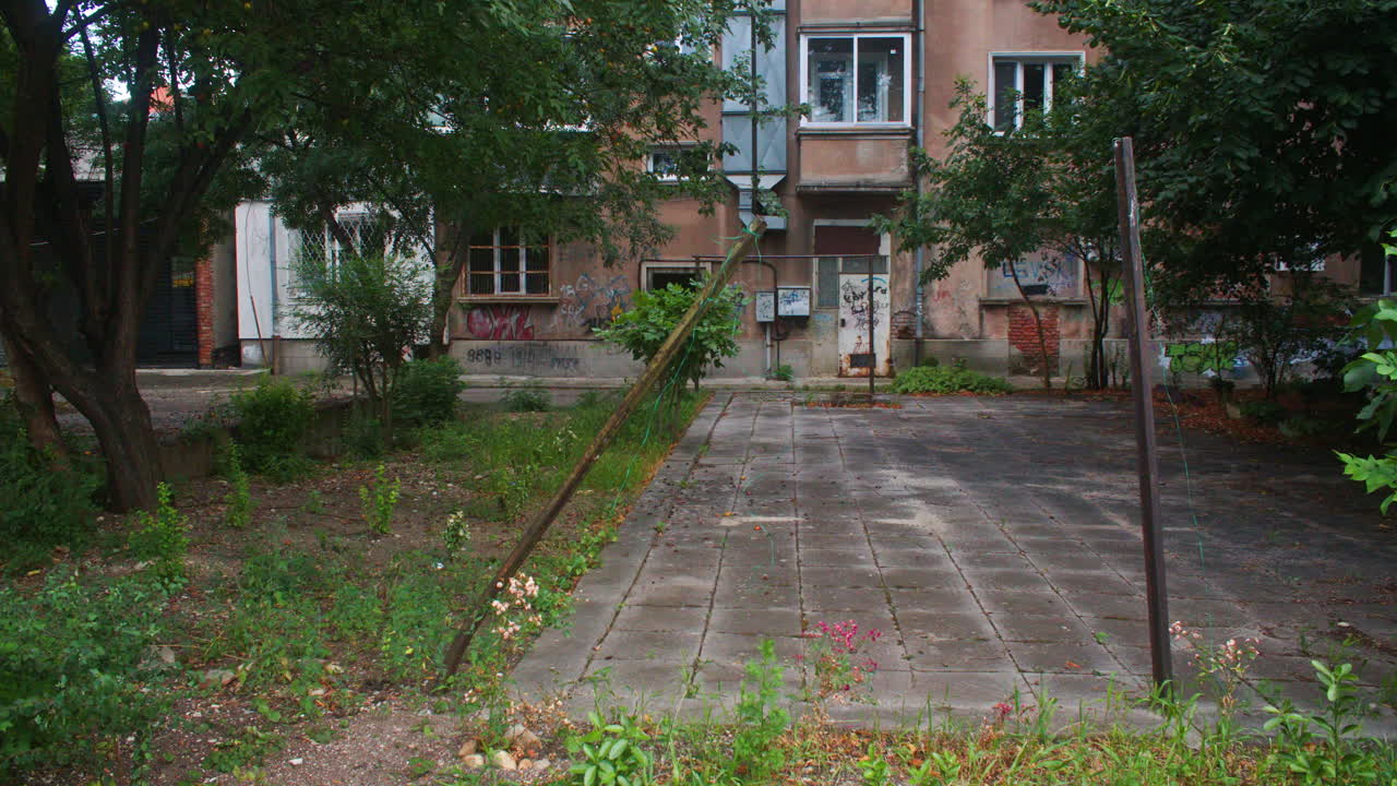 An old, dilapidated, brutalist apartment building from the communist era in Sofia, Bulgaria and some trees in front of it