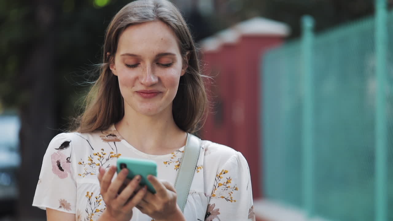 Giovane donna felice che si scatta un selfie e usa lo smartphone all'aperto.
