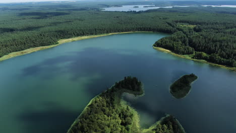 shadows of clouds swimming over majestic lake landscape of lithuania, aerial drone view