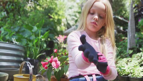 little girl putting gloves before gardening