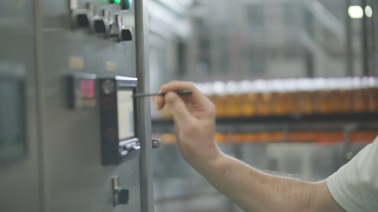 Factory worker operating machinery in a beverage bottling plant
