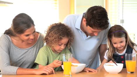 familia en la cocina con cuencos de cereales
