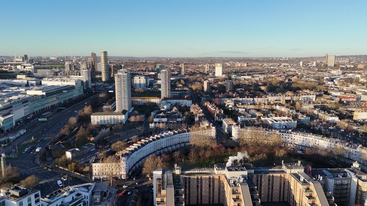 Crescent of houses Panning drone aerial to Westfield shopping centre Sheppards Bush London UK