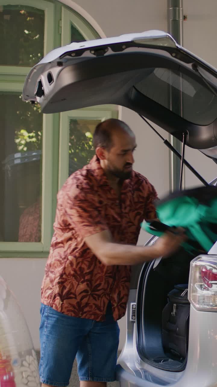 Uomo che prepara il bagagliaio dell'auto per le vacanze