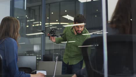 Mixed-race-businessman-using-drone-during-meeting