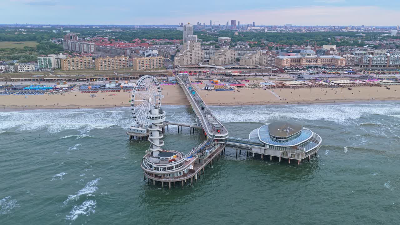 Panorama dal drone del Molo di Scheveningen al tramonto, ruota panoramica sul mare scintillante, Paesi Bassi