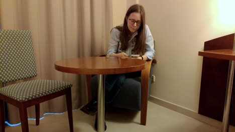 young woman looking at her money and her smartphone