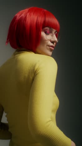 woman in a yellow turtleneck with red hair and glasses