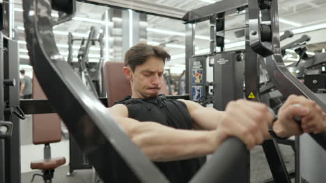 Mid-Age-Australian-Man-Trains-Middle-Chest-Muscles-Doing-Seated-Chest-Press-Exercise-in-Hammer-Strength-Machine---close-up