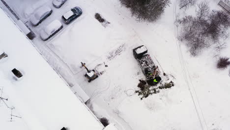 construction worker team digging hole for electricity pole with heavy machinery, aerial downwards view