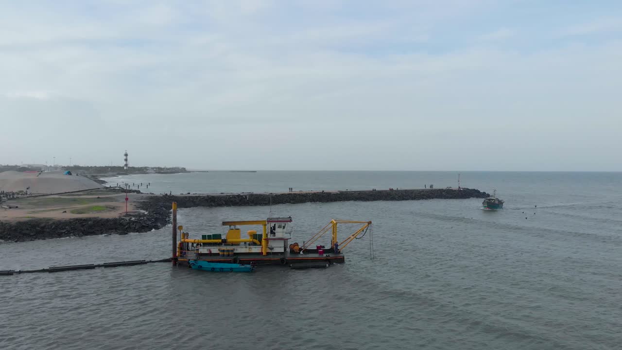 toma aérea de paso elevado de un barco draga utilizado para excavar la tierra cerca del puerto de pondicherry, filmada con un dron en 4k