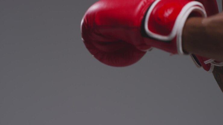 Close Up Studio Shot Of Two Male Boxers Wearing Gloves Fighting In Boxing Match Against Grey Background 13