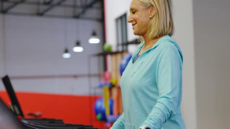 Senior-woman-exercising-on-treadmill-in-fitness-studio-4k