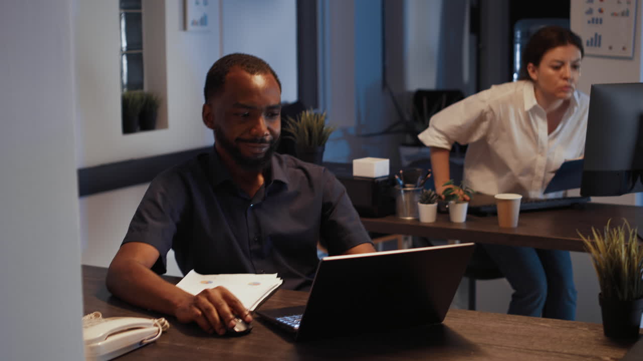 Male manager analyzing charts on documents and laptop