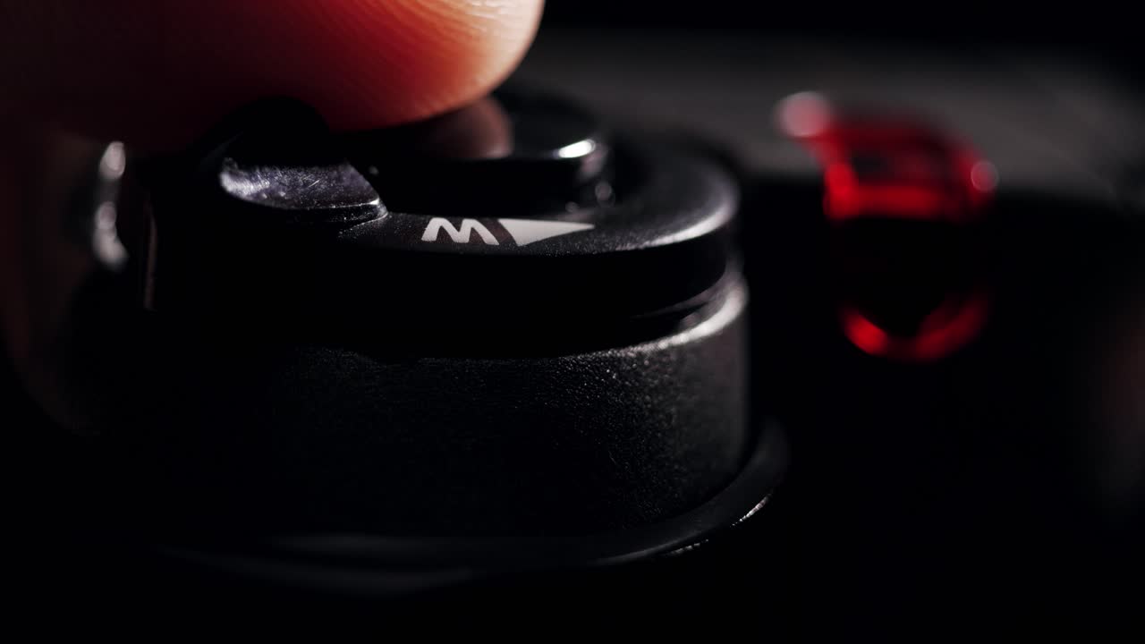 Macro shot of finger pressing shutter button on digital camera with flash firing