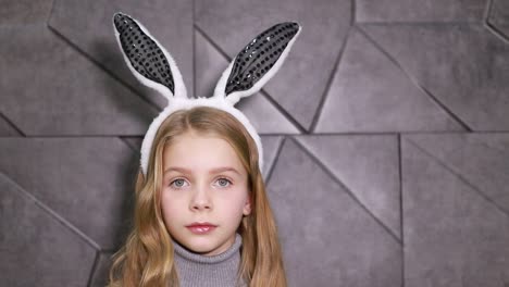 portrait of a cute little girl dressed in ears easter bunny, happy baby waiting for the holiday