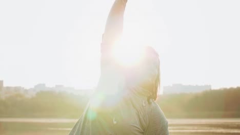 young woman stretching her arms and hands before running