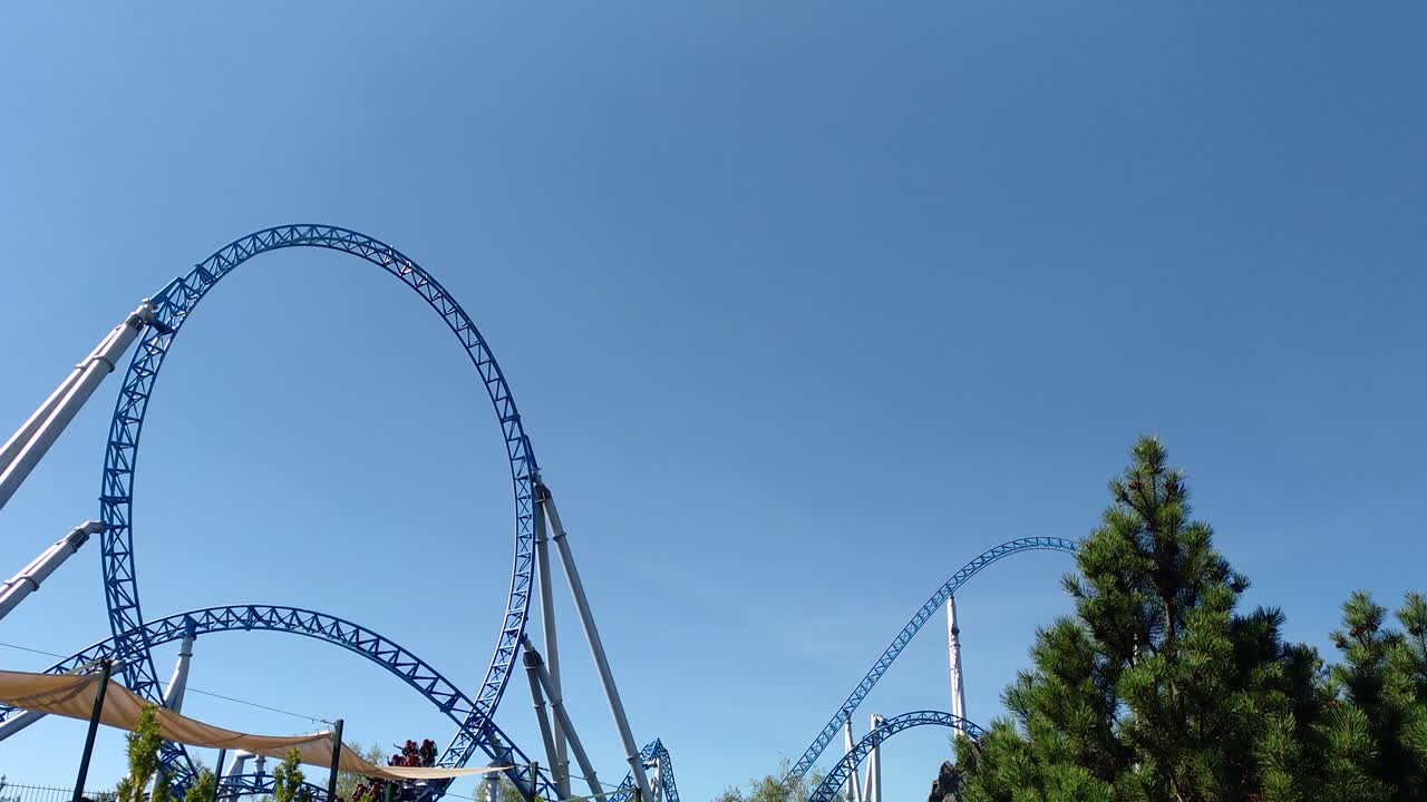 Delle montagne russe che percorrono un looping in un parco a tema.