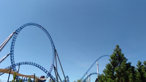 a roller coaster rides through a looping in a theme park