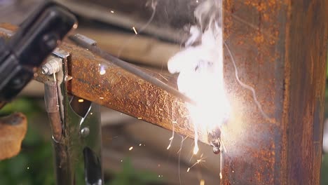 slow motion closeup hand holds welding tool for fixing fence