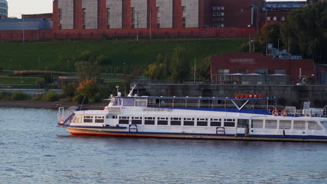 passenger boat on a river with city buildings in the background