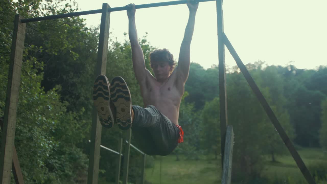 hombre en topless en forma joven que hace levantamientos de rodillas para hacer ejercicio de l-sit para fortalecer los músculos centrales 6 paquetes de entrenamiento de abdominales