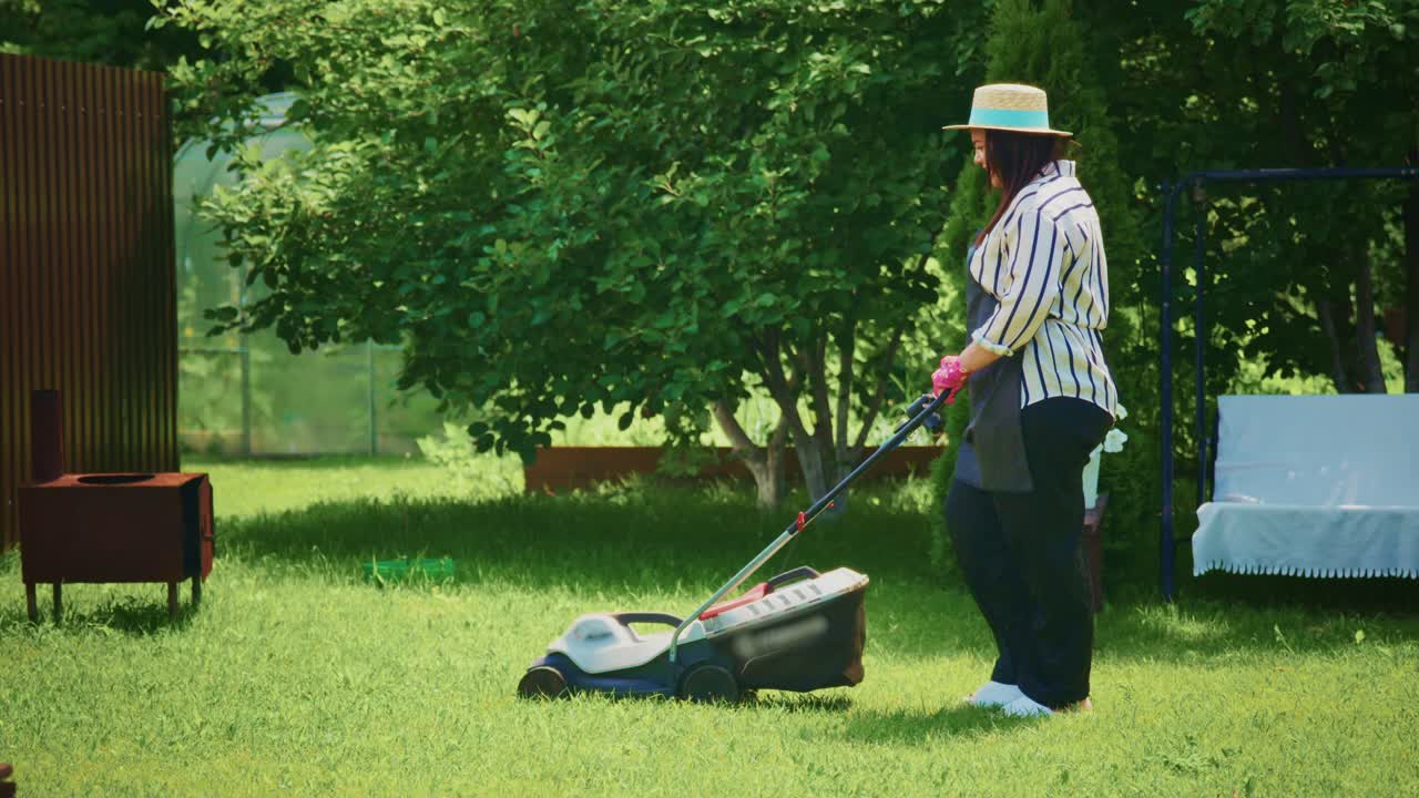 Woman mowing the lawn in a garden