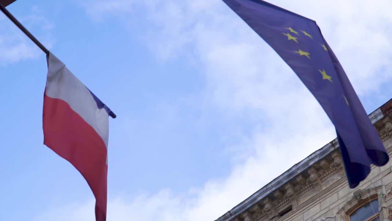 Bandiere sventolanti della Francia e dell'Unione Europea con cielo blu sullo sfondo
