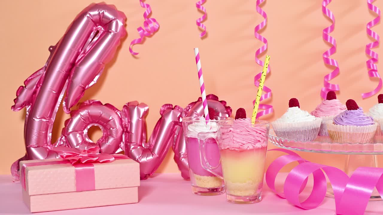 mesa dulce con deliciosos postres, pasteles, pudines y globos. detener el movimiento