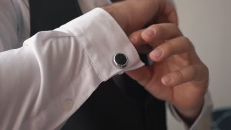 close-up men's hands fastens the buttons on shirt