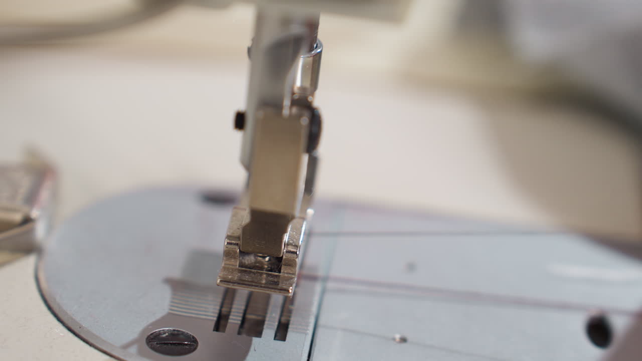 Close up view of female hand drawing out fabric from sewing machine, carefully pulling material, ensuring precise alignment, highlighting delicate technique, demonstrating professional focus