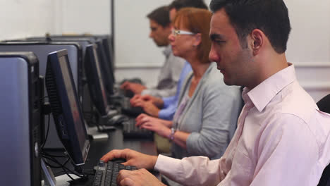 clase de estudiantes maduros que trabajan en la clase de computadora