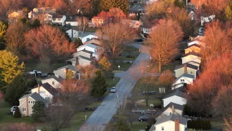 Long-aerial-zoom-of-American-neighborhood-during-golden-hour-sunset-in-late-winter-and-early-spring