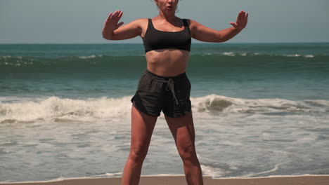 mujer haciendo sentadillas en la playa